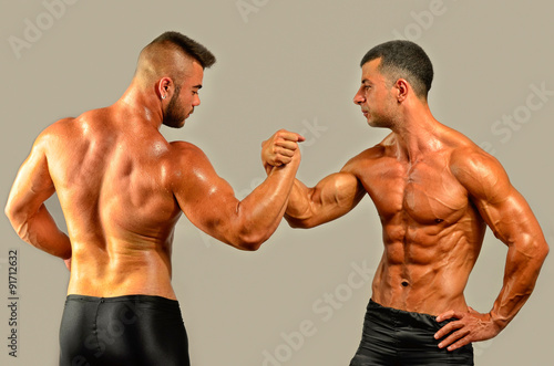 Strong bodybuilders testing their biceps in a skandemberg contest