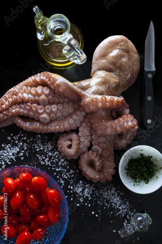 octopus with fresh raw ingredients: olive oil, tomatoes, parsley