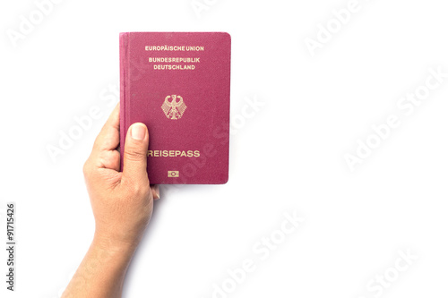 Close up hand holding German passport isolated on white