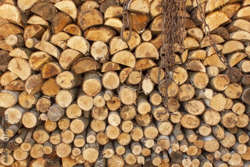 Background of stacked wood. Ready firewood. Various kinds of wooden logs stacked on top of each other. Stack of wood  firewood  background. Dry chopped firewood logs ready for winter.  