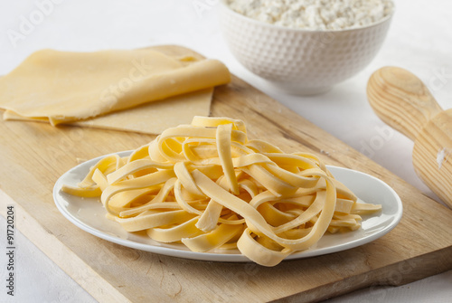 Raw homemade tagliatelle on a kitchen table