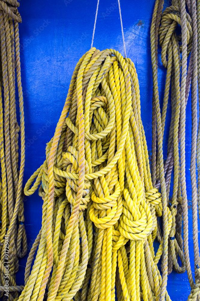 Yellow rope hanging next to a blue wall