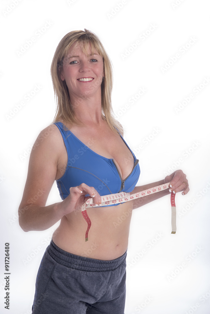 Woman wearing a sports bra checking under bra measurement with a tape  measure Stock Photo | Adobe Stock
