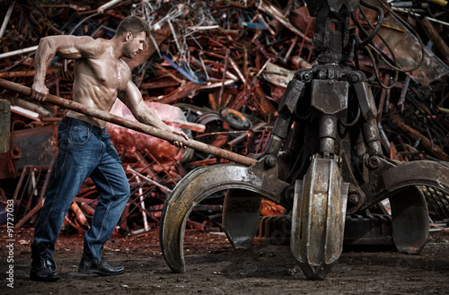 Muscular man working on junkyard