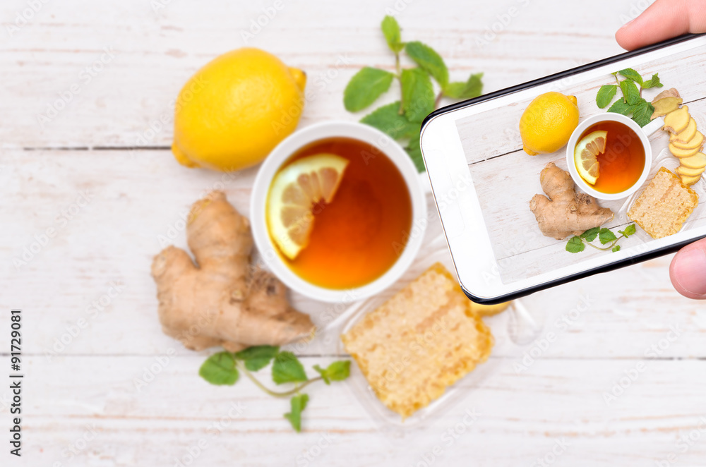 Hands taking photo ginger tea with smartphone. Hands taking photo ginger tea with smartphone.