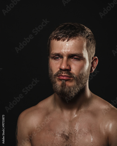 Athletic bearded boxer on a dark background