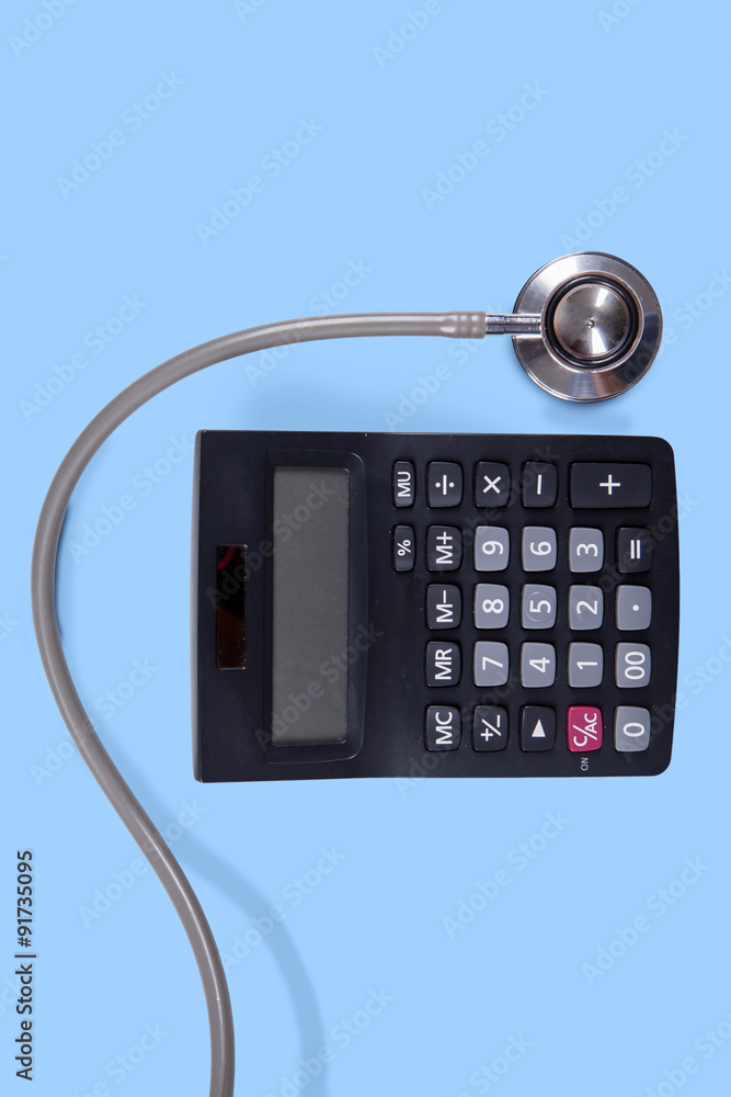 Calculator and stethoscope on blue background Calculator and stethoscope on blue background