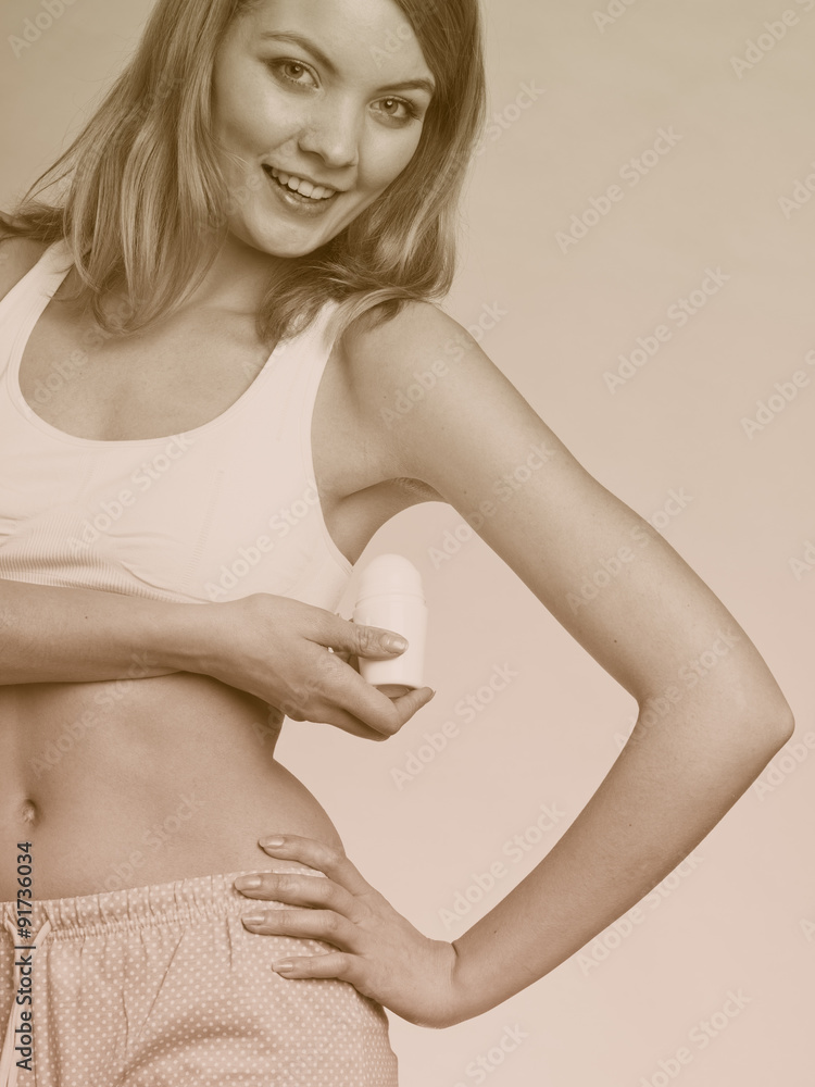 Fototapeta premium Girl applying stick deodorant in armpit.