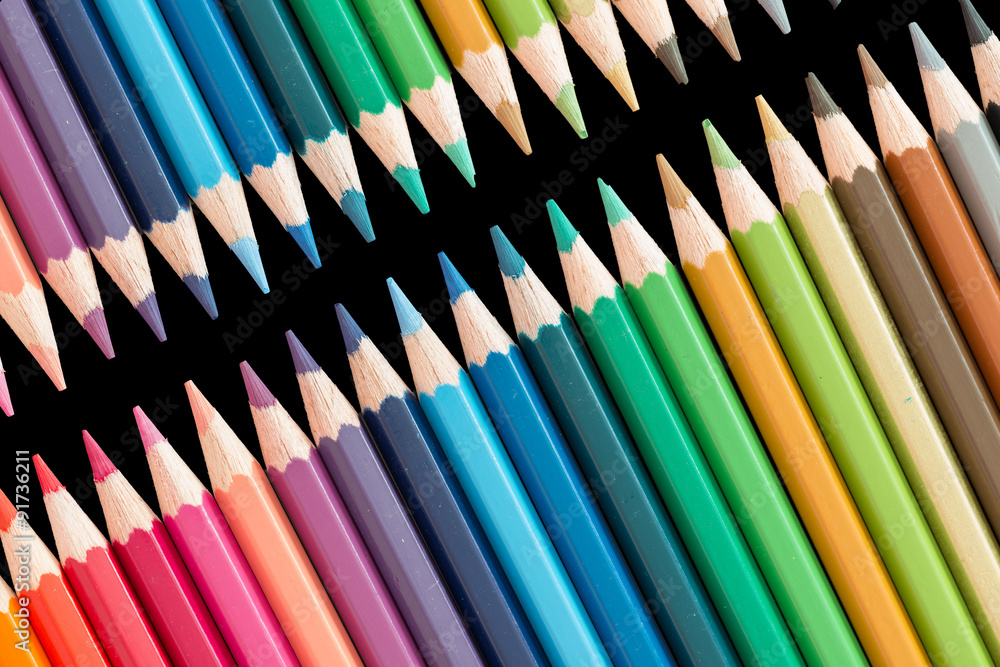 wooden color pencils lying in a row on black wooden color pencils lying in a row on black