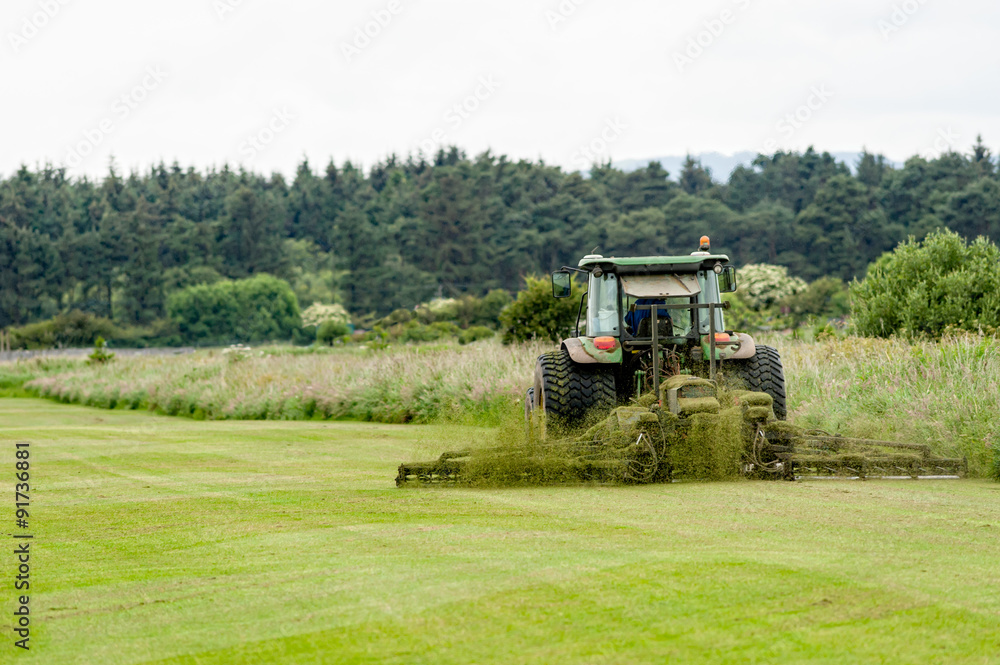 Tractor with grass cutter mowing lawn. Tractor with grass cutter mowing lawn.