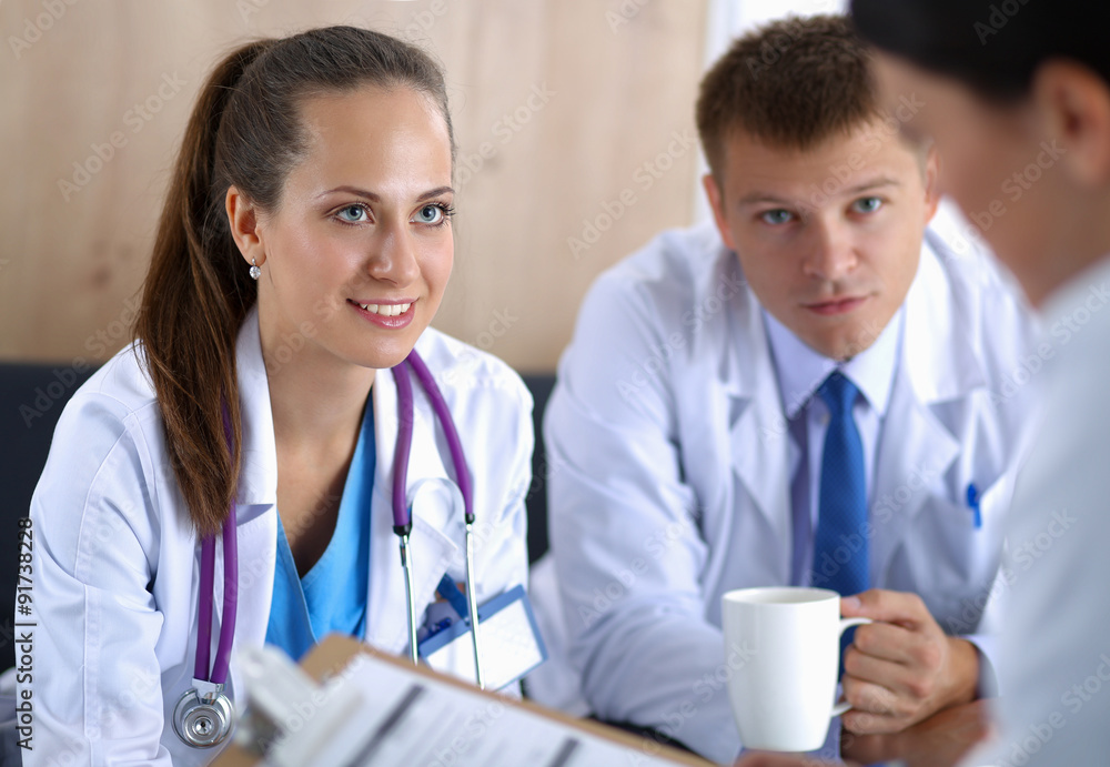 A group of doctors dscussing patient details. A group of doctors dscussing patient details.