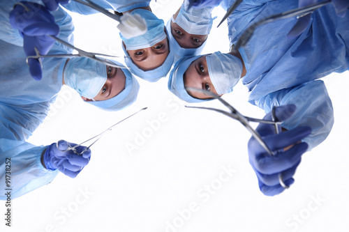 View from below of masked doctors looking at patient before