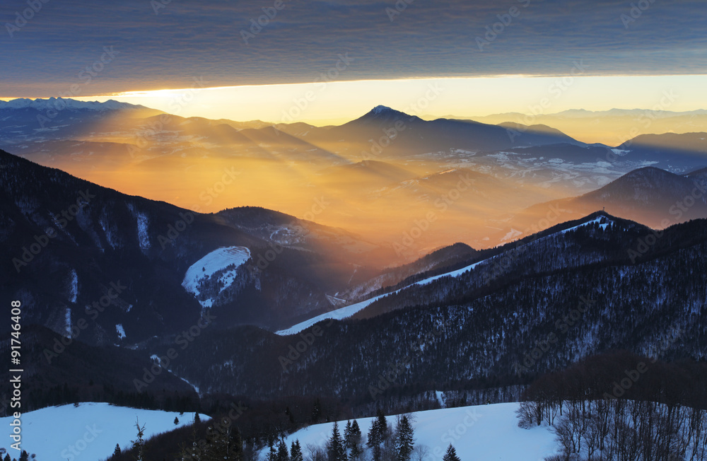 Sunset over color mountain silhouette with rays Sunset over color mountain silhouette with rays