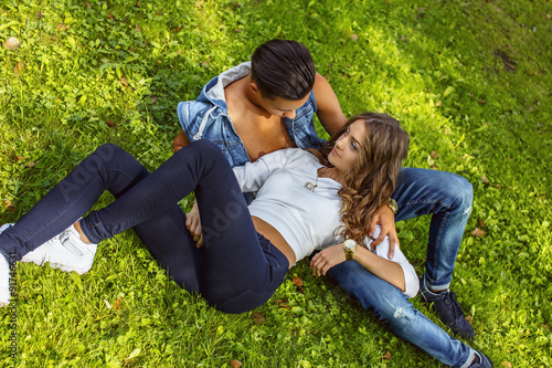 Young couple lying on grass field.