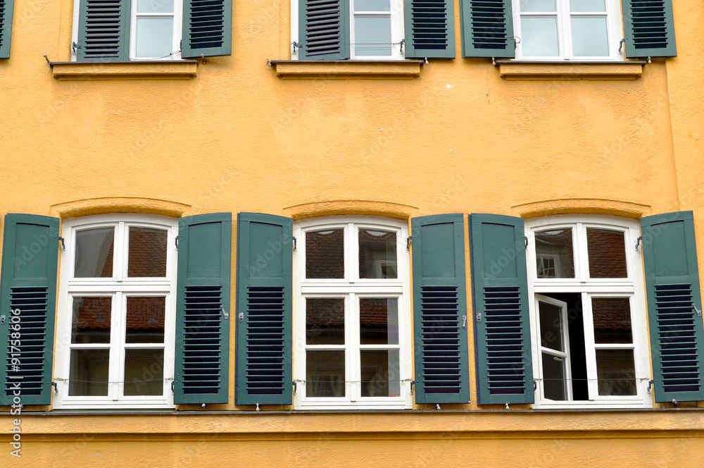 Windows with shutters on yellow wall Windows with shutters on yellow wall