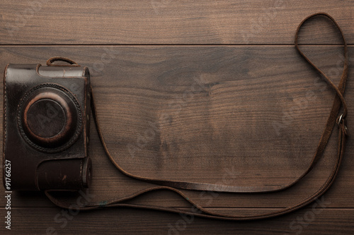 wooden background with retro still camera