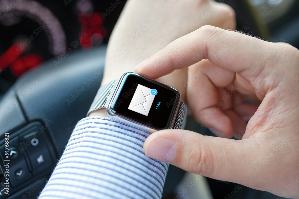 Man hand in car with watch and e-mail on screen Man hand in car with watch and e-mail on screen