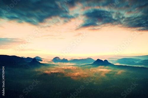 Tourist resort in Saxony. Fantastic dreamy sunrise on the top of the rocky mountain with the view into misty valley © rdonar