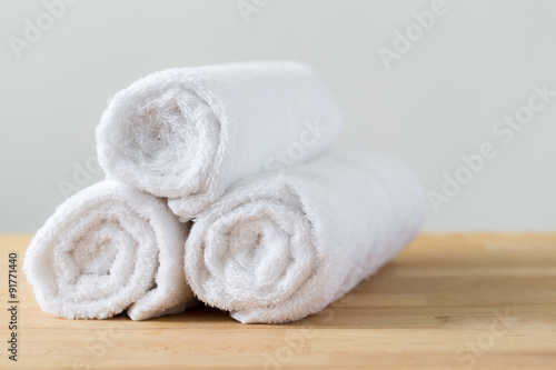 White spa towels pile on wooden table