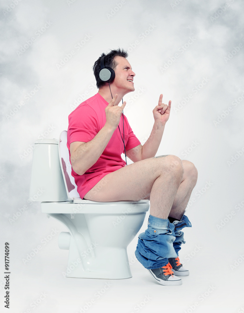 Man in headphones sitting on the toilet. Yes!