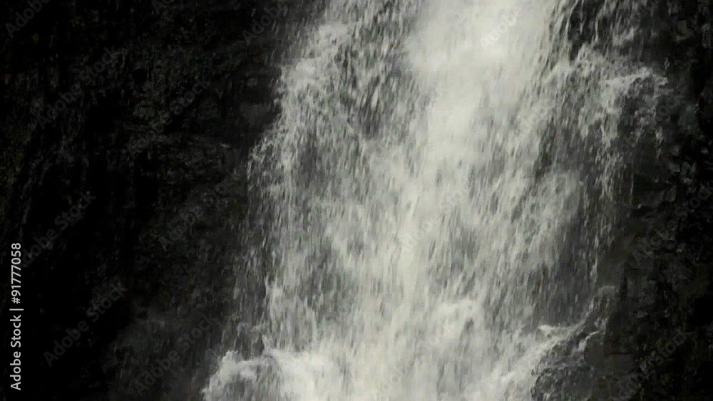 A close up of a waterfall flowing into a pool followed by a slow tilt upward. A close up of a waterfall flowing into a pool followed by a slow tilt upward.