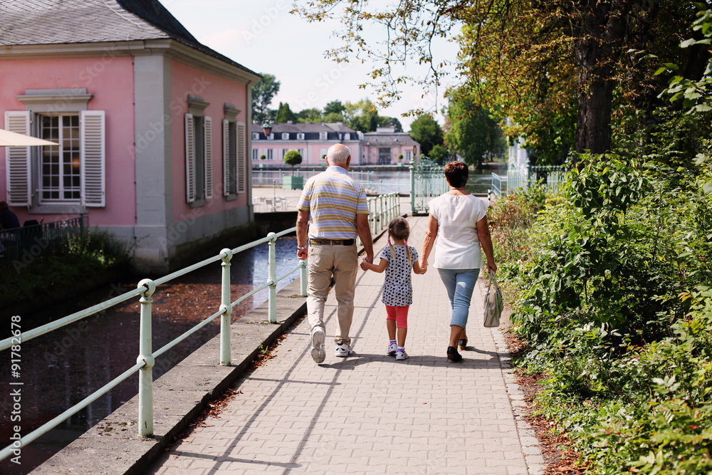 Obraz premium Grandparents With Grandchildren walking together in the park