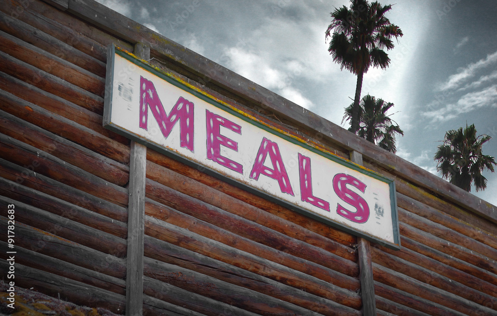 aged and worn vintage photo of meals sign with palm trees