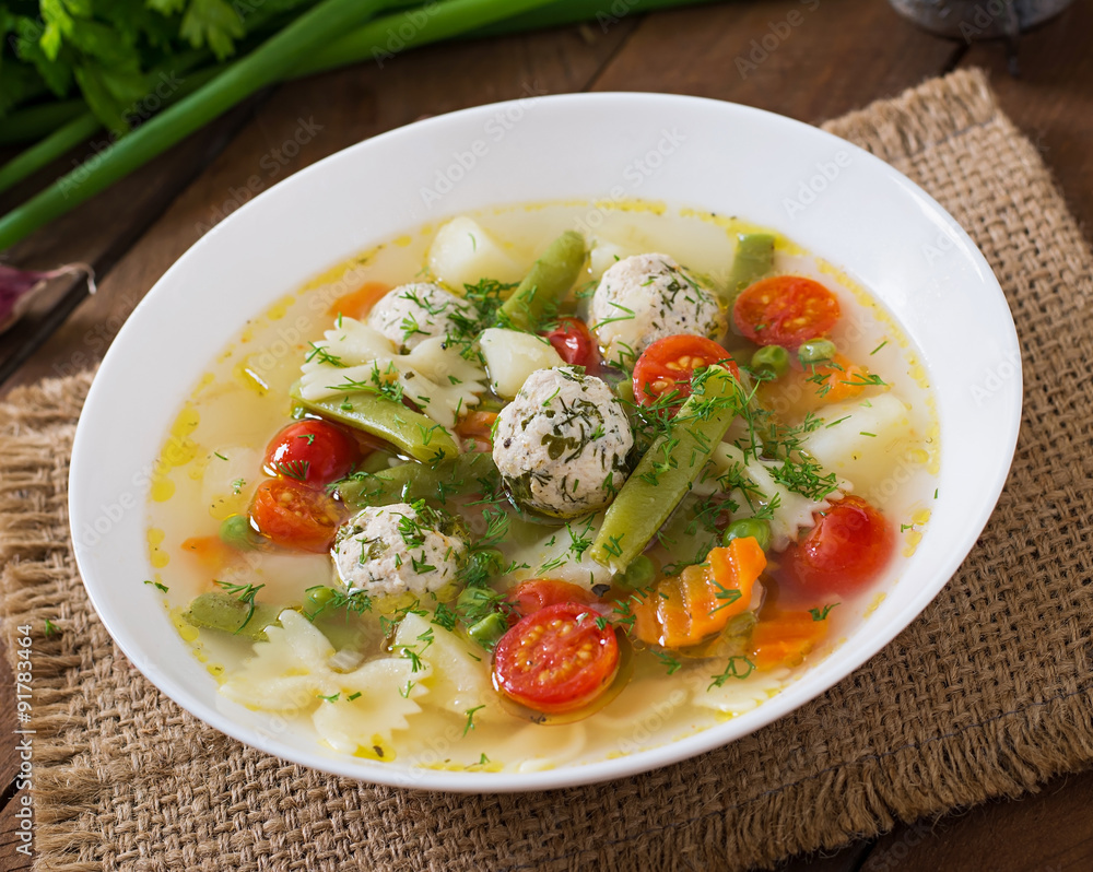 Diet vegetable soup with chicken meatballs and fresh herbs in bowl Diet vegetable soup with chicken meatballs and fresh herbs in bowl