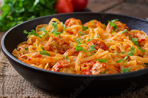 Pasta linguine with meatballs in tomato sauce.
