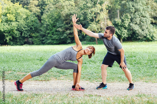 Personal trainer helps a woman during exercise photo