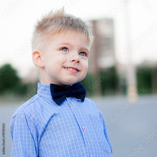 Stylish baby boy with blond hair. A boy is wearing the checked s