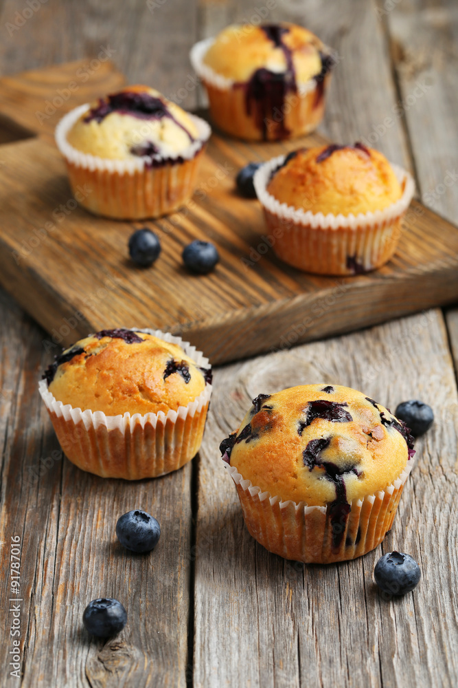 Tasty blueberry muffins on a grey wooden background
