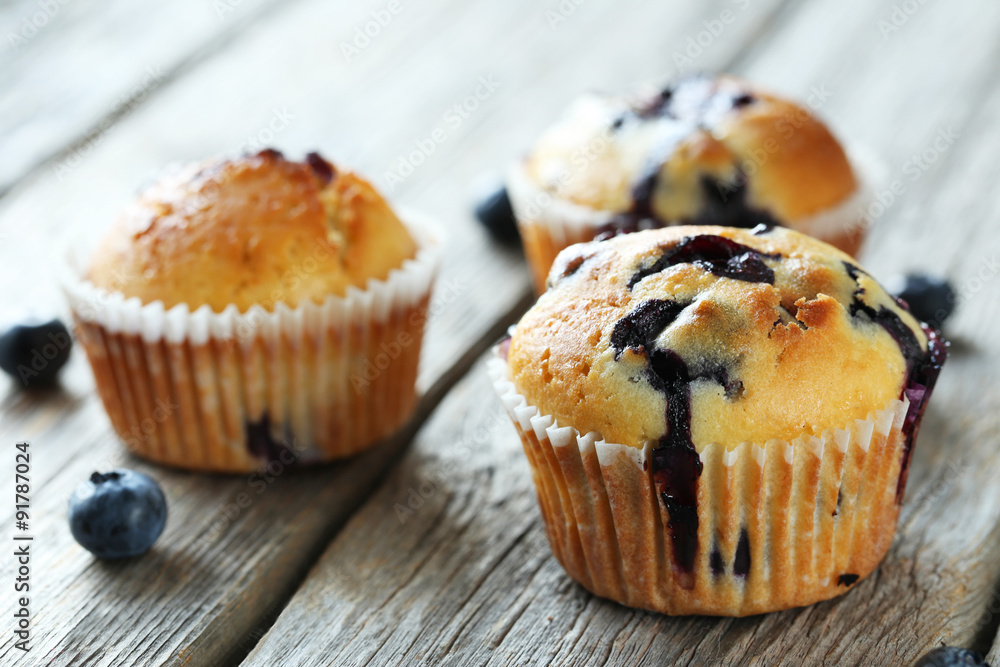 Tasty blueberry muffins on a grey wooden background Tasty blueberry muffins on a grey wooden background