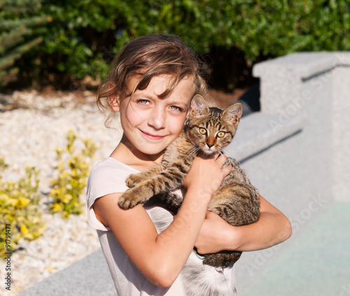 Girl cradeling kitten in her arms