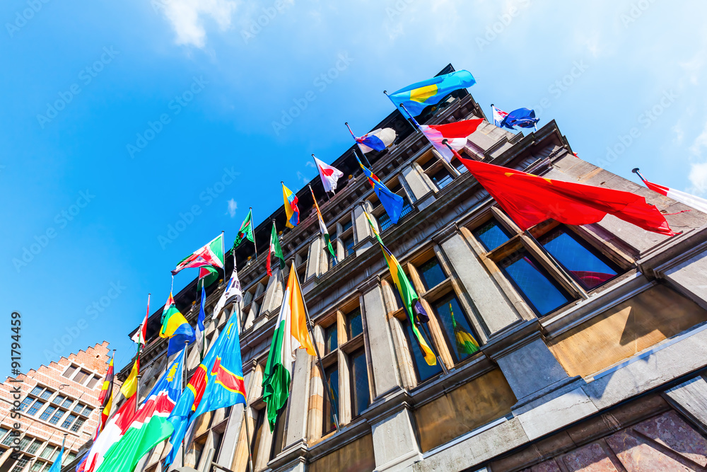 Fassade des historischen Rathauses in Antwerpen mit bunten Flaggen