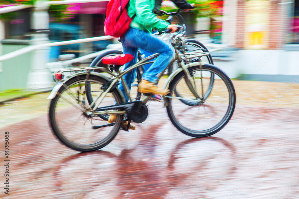 Fototapeta premium Radfahrer bei Regenwetter in Bewegungsunschärfe