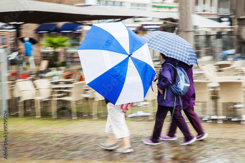 Gruppe von Touristinnen in einer holländischen Altstadt bei starkem Regen