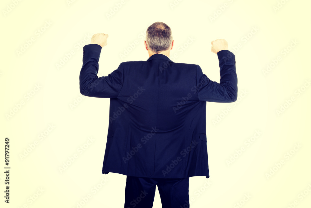 Back view successful businessman with arms up Back view successful businessman with arms up