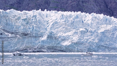 Sailboat in front of the tidewater Margerie Glacier calving in Glacier Bay National Park, Alaska.