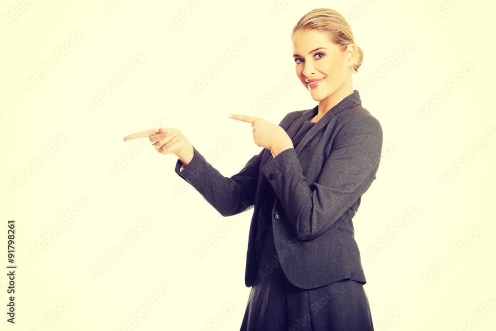 Business woman pointing at copyspace on the left Business woman pointing at copyspace on the left