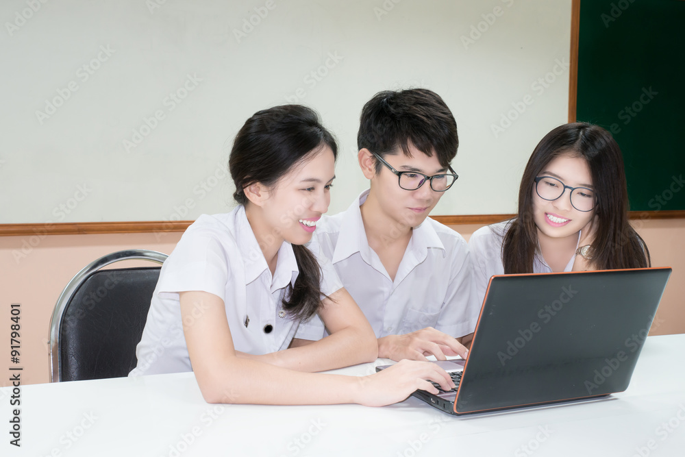 Group of Asian student in uniform E-learning through Laptop in c Group of Asian student in uniform E-learning through Laptop in c