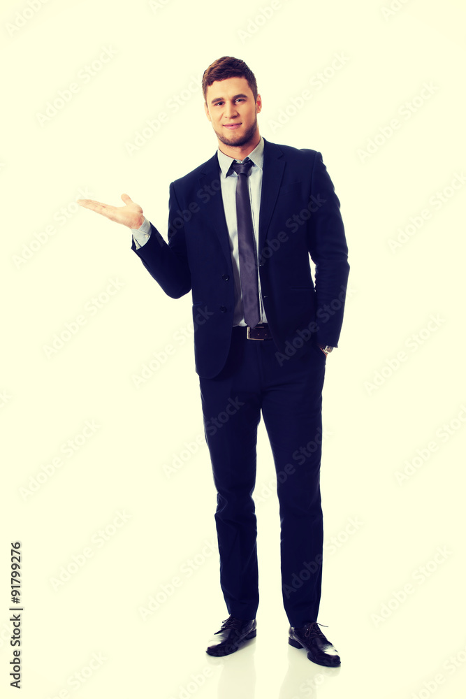 Handsome businessman holding copyspace on palm. Handsome businessman holding copyspace on palm.