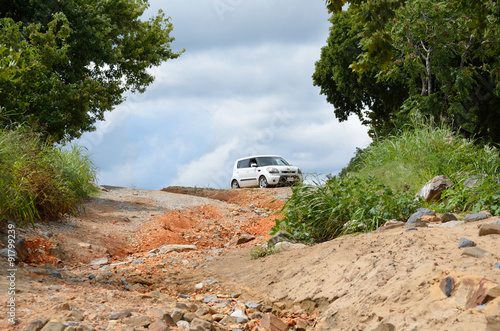 Small white car sitting at the top of a ravine