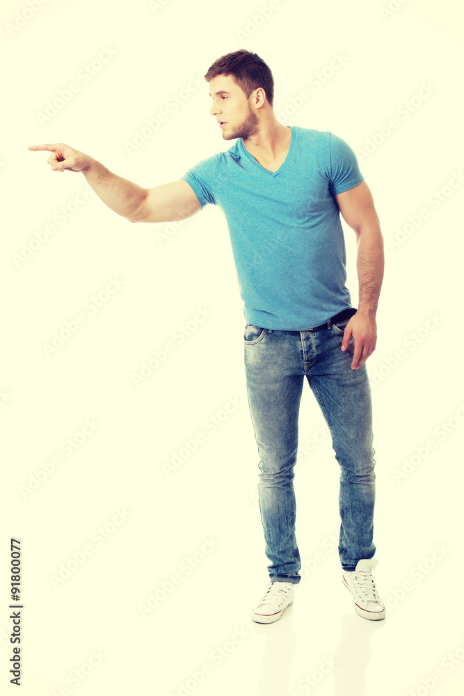 Handsome young man pointing up. Handsome young man pointing up.