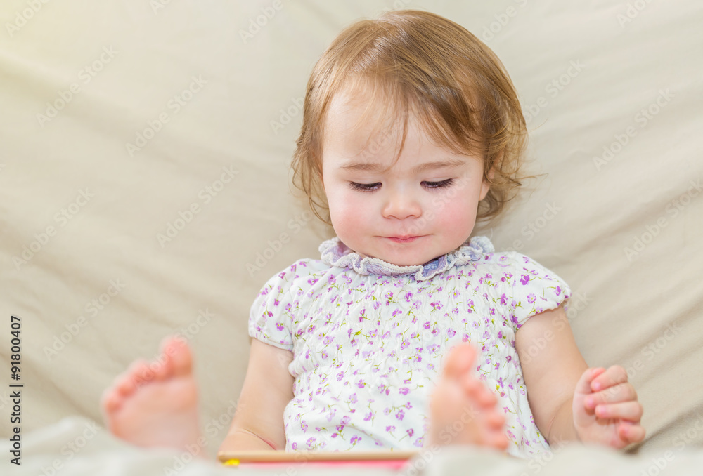 Happy toddler girl using a tablet computer Happy toddler girl using a tablet computer