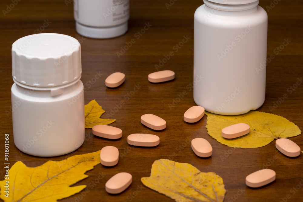 Orange pills and medicine bottle on wooden background Orange pills and medicine bottle on wooden background