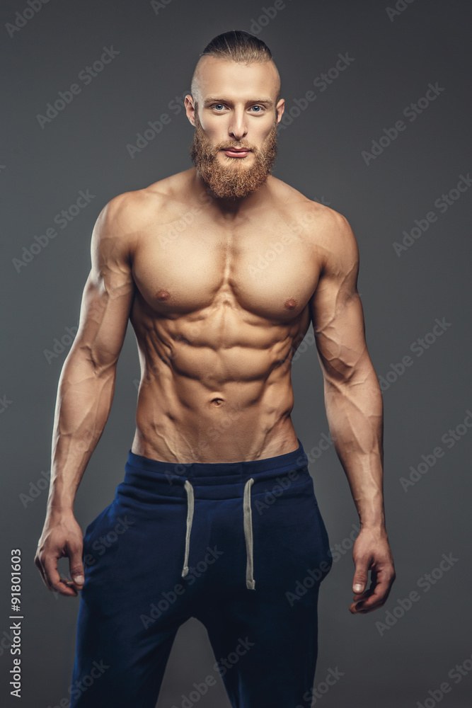 Fototapeta premium Shirtless muscular guy posing over grey background.