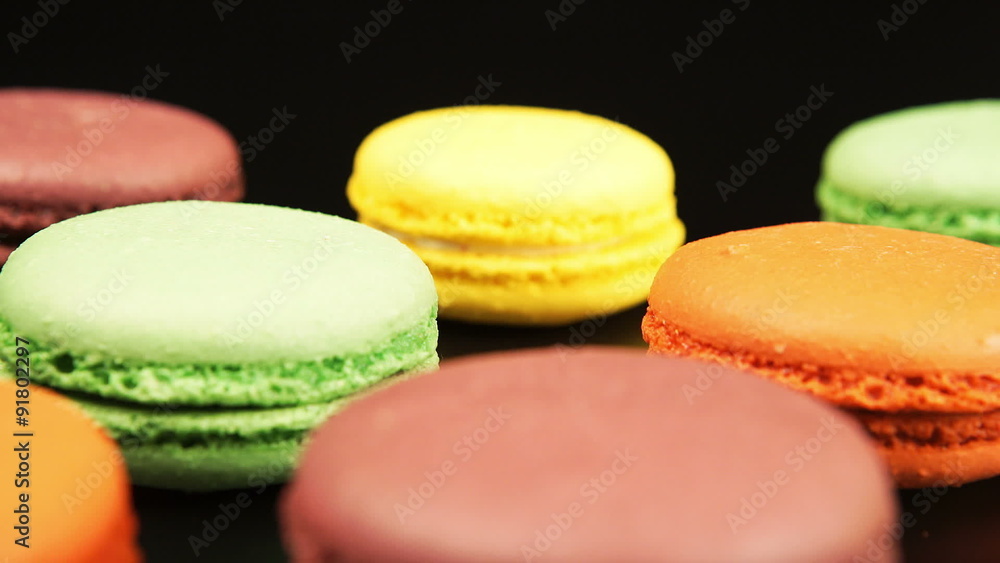 TRACKING: A colorful macaroons is on the black table
