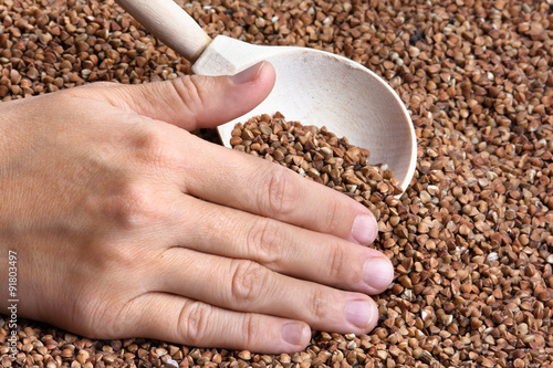 hand with buckwheat in spoon