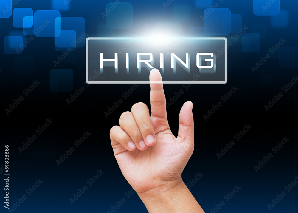 Hand pressing HIRING button to find new job on technology background Hand pressing HIRING button to find new job on technology background
